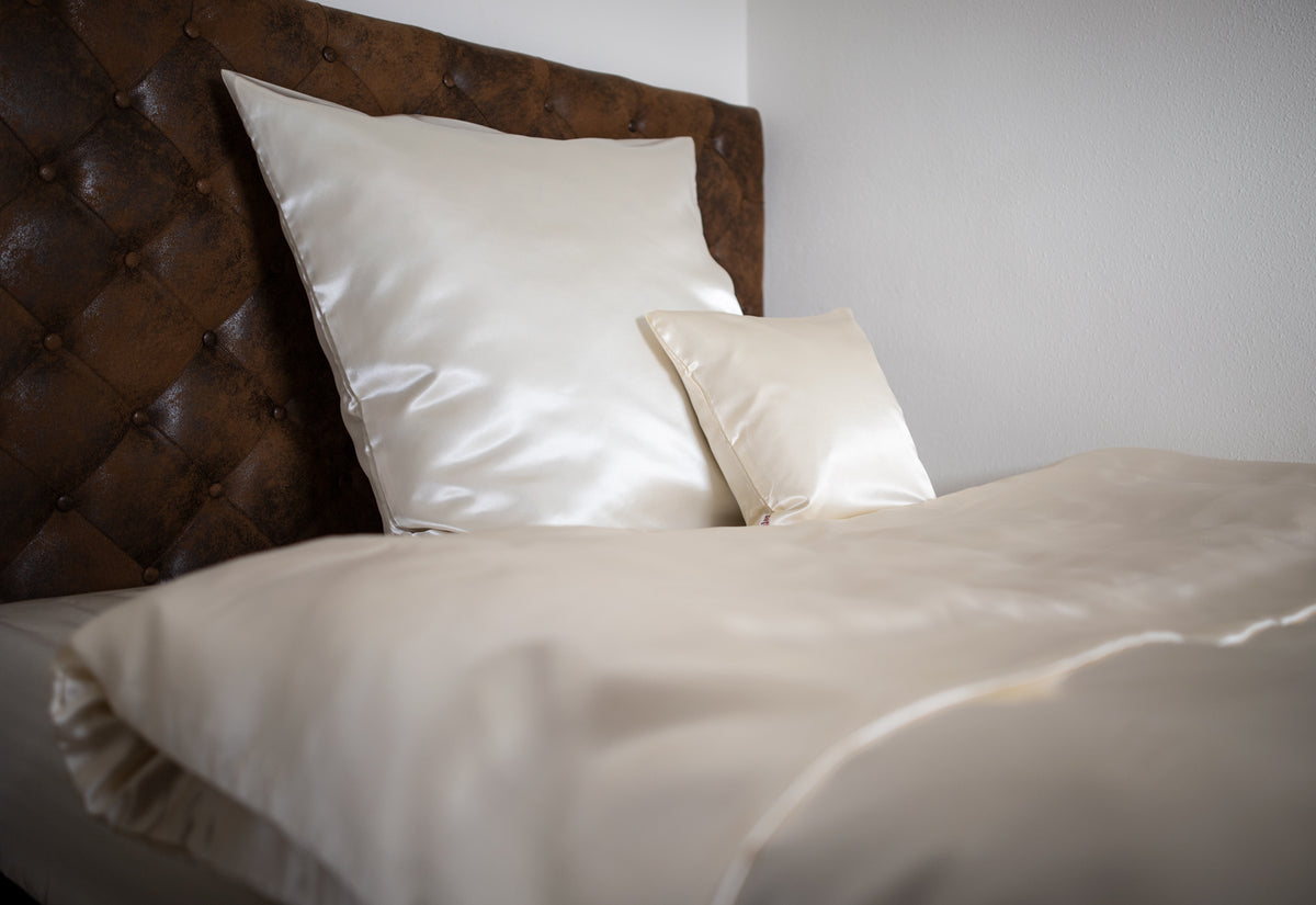 Champagner Farbene Glanz Satin Bettwäsche, dekoriert in einem braunen Lederbett.