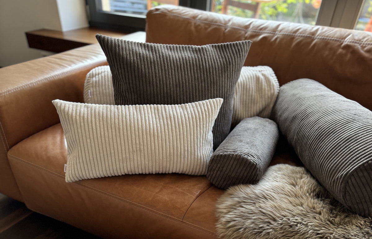 Ledersofa mit Cord-Kissen, Nackenrolle und XL-Rolle in Grau, Creme und Anthrazit – beties HYggelig No.2