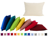 Ein hellbeiges, rechteckiges Kissen auf einem weissen  Hintergrund. Darunter ist eine Kissenreihe mit Kissenbezuegen in den kraeftigen Farben royal-blau, petrol, apfelgruen, gelb, altrosa, rot und hibiskus.