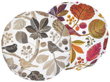 Zwei runde Kissenbezuege mit Blaetter, Zweigen und Voegeln auf weissem Hintergrund bedruckt. Einer ist in den Farben braun/taupe und der andere ist ganz bunt gehalten.