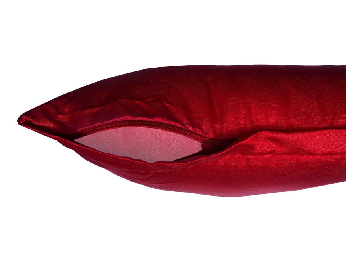 Detailansicht eines verdeckten Reissverschlusses an einem karmin-roten Kissenbezug.