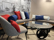 Kissen mit 3D-Waben-Bezügen in Weiß, Blau und Rot auf dem Sofa – beties Rhythm